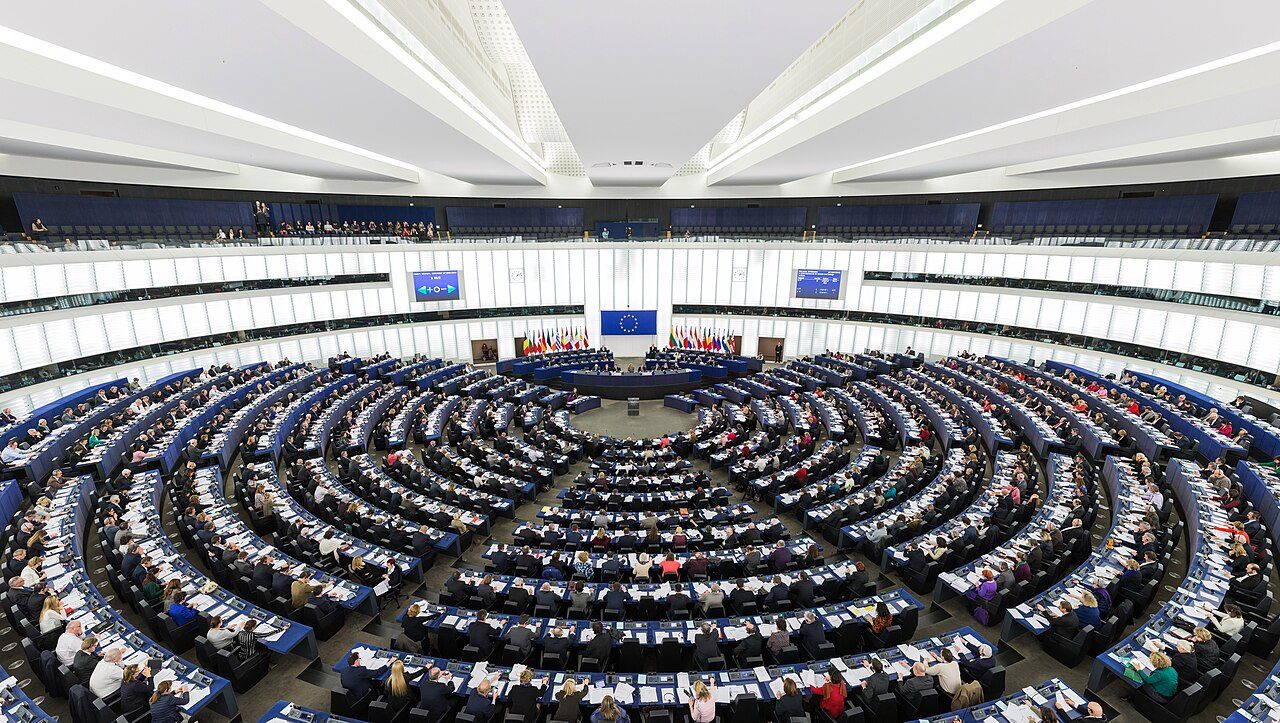 Gran sala semicircular con cientos de escaños azules ocupados por diputados frente a la mesa presidencial