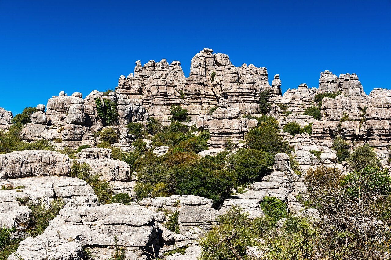 Rocas calizas grises en forma de columnas y bloques apilados, con surcos y grietas producidos por la disolución