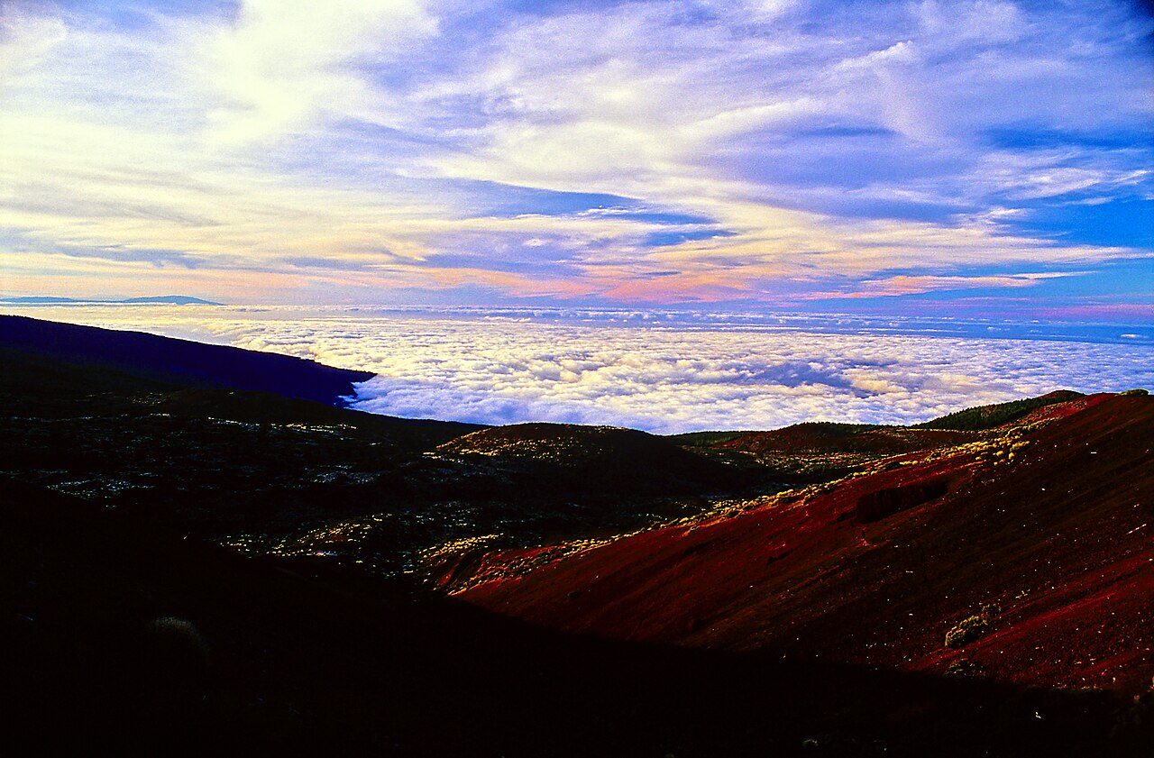 Capa continua de nubes blancas sobre la vertiente norte de Tenerife, con la ladera volcánica en primer plano.