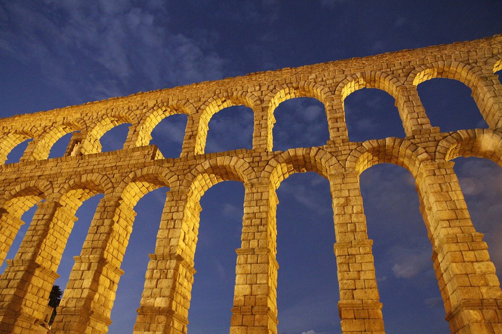 Arcos de granito del acueducto de Segovia al anochecer