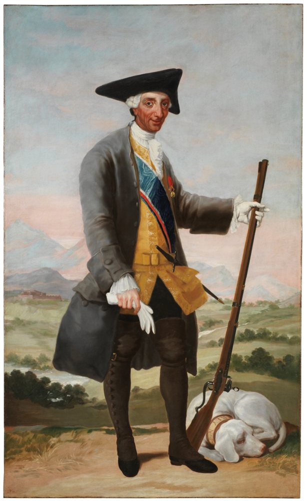 Rey anciano de cuerpo entero, vestido de cazador, con escopeta y un perro a sus pies.