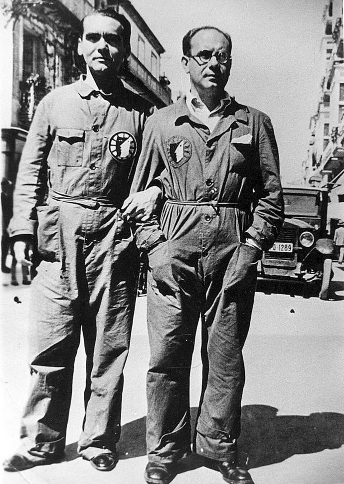 Fotografía en blanco y negro de Federico García Lorca y Eduardo Ugarte con monos de trabajo y la insignia de La Barraca