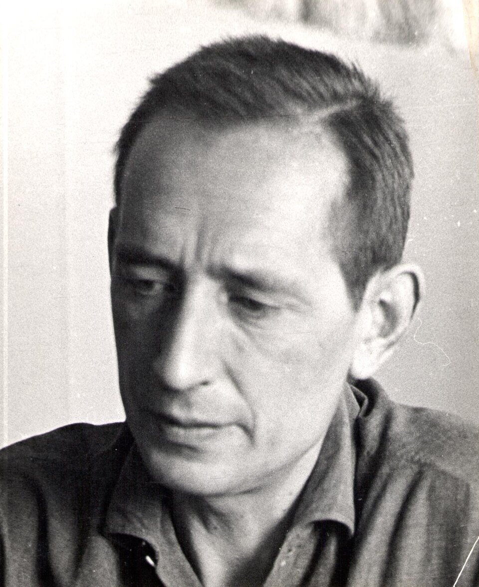 Retrato en blanco y negro de Miguel Delibes, de mediana edad, con la mirada baja
