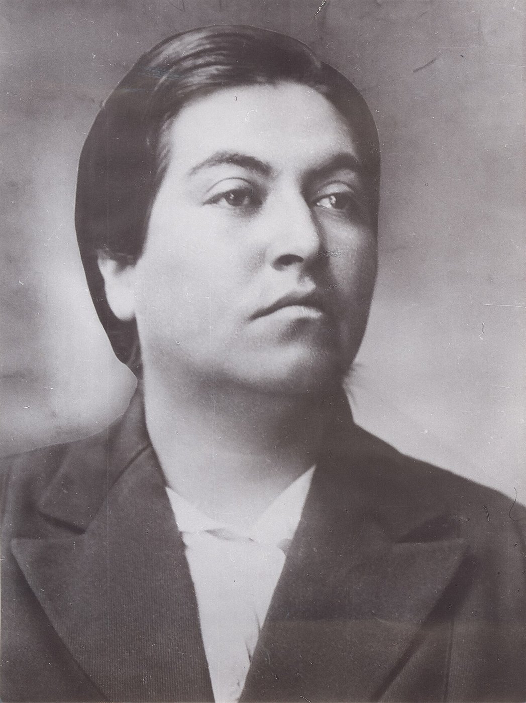 Retrato en blanco y negro de Gabriela Mistral, joven, con el pelo recogido y mirada seria